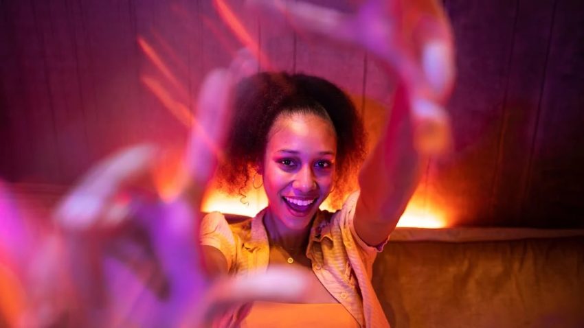 Young woman enjoying a lively night out with vibrant lighting and a joyful atmosphere.